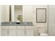 Bathroom featuring double sink vanity with white cabinets, gray countertop, framed wall art, toilet, and tiled shower at 1283 Dora Parc Ln, Mount Dora, FL 32757