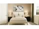 Neutral bedroom features an upholstered bed, black nightstands, lamps, and a large art piece above the bed at 1283 Dora Parc Ln, Mount Dora, FL 32757