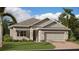 Charming single-Gathering home featuring a two-car garage, stone accents, and lush landscaping at 1283 Dora Parc Ln, Mount Dora, FL 32757