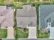 Aerial view of home with a well-manicured lawn, mature landscaping, and a unique patterned driveway at 1709 Latta Ct, The Villages, FL 32162