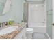 Bathroom featuring granite countertop, white vanity, and a shower-tub combination at 1709 Latta Ct, The Villages, FL 32162