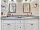 Bathroom featuring dual sinks, granite countertops, and white cabinets at 1709 Latta Ct, The Villages, FL 32162