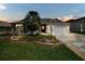Inviting home with stone walkway, manicured lawn, and mature landscaping around the front yard and garage at 1709 Latta Ct, The Villages, FL 32162