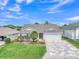 Beautiful single-Gathering home featuring a well-manicured lawn, mature landscaping, and a decorative patterned driveway at 1709 Latta Ct, The Villages, FL 32162
