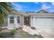 Charming home with a well-maintained front exterior, beautiful landscaping, and an attached two-car garage at 1709 Latta Ct, The Villages, FL 32162