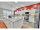 Modern kitchen island with elegant white cabinets, marble countertops, and stainless-steel appliances at 1709 Latta Ct, The Villages, FL 32162