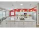 Spacious kitchen island featuring white cabinetry, marble countertops and stainless steel appliances at 1709 Latta Ct, The Villages, FL 32162