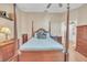 Comfortable main bedroom featuring a four-poster bed and matching wooden dressers at 1709 Latta Ct, The Villages, FL 32162