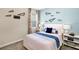 A bedroom with paper airplane wall decor, carpeted floors, and blue accent pillows at 1899 Clear Sky Dr, Kissimmee, FL 34744