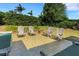 Outdoor patio seating area with well-maintained landscaping, mature trees, and manicured hedges at 2417 Coventry Ave, Lakeland, FL 33803