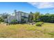 Expansive backyard with a charming patio, lush greenery, and a classic white stucco home at 2417 Coventry Ave, Lakeland, FL 33803
