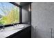 Modern bathroom features a sink with a view to bamboo, dark cabinets and white marble walls at 2417 Coventry Ave, Lakeland, FL 33803