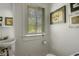 Charming bathroom featuring a pedestal sink, white fixtures, and natural light at 2417 Coventry Ave, Lakeland, FL 33803