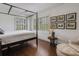 Bedroom featuring a four-poster bed, hardwood floors, and white walls with natural light at 2417 Coventry Ave, Lakeland, FL 33803