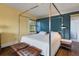 Spacious bedroom with modern four poster bed, hardwood floors, and ample natural light at 2417 Coventry Ave, Lakeland, FL 33803