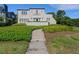 Charming two-story home boasts a red tile roof, balcony, and meticulously landscaped front yard at 2417 Coventry Ave, Lakeland, FL 33803