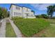 Elegant two-story white stucco home features a red tile roof, balcony, and beautifully landscaped front yard at 2417 Coventry Ave, Lakeland, FL 33803