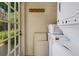 Bright laundry room with stacked washer and dryer and access to the outdoors at 2417 Coventry Ave, Lakeland, FL 33803