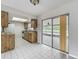Bright kitchen with wood cabinets provides sliding glass door access to the outdoor screened patio at 9526 Turkey Oak Bnd, Orlando, FL 32817