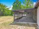 Outdoor living at its finest: a screened-in porch with a ceiling fan and scenic backyard view at 9526 Turkey Oak Bnd, Orlando, FL 32817