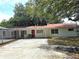 Quaint home with a red metal roof, white siding, and mature trees at 5045 Swindell Rd, Lakeland, FL 33810