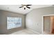 Cozy bedroom featuring a ceiling fan, window views, and access to the adjoining bathroom at 2352 Grand Central Pkwy # 18, Orlando, FL 32839
