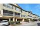 Townhouse complex with garages, screened balconies, manicured landscaping, and brick-paved driveways at 2352 Grand Central Pkwy # 18, Orlando, FL 32839