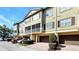 A multi-story condo building with brick-paved driveways, trimmed bushes, and cream-colored stucco at 2352 Grand Central Pkwy # 18, Orlando, FL 32839