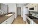 Galley kitchen with white cabinets, stainless steel appliances, and tile flooring at 2352 Grand Central Pkwy # 18, Orlando, FL 32839