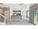 Open-plan living room with stairs, white ceiling fan, access to the kitchen, and neutral colored carpet at 2352 Grand Central Pkwy # 18, Orlando, FL 32839
