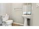 Clean powder room offering a pedestal sink, toilet, and a mirror that extends the visual space at 2352 Grand Central Pkwy # 18, Orlando, FL 32839