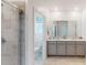 Well-lit bathroom featuring a glass-enclosed shower and double vanity with neutral-toned cabinets at 608 Terrapin Dr, Debary, FL 32713