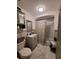 Well-lit bathroom featuring a vanity, toilet, and shower with a marble tile surround at 166 Catfish St, Haines City, FL 33844