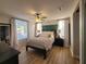 Comfortable bedroom features a wood accent wall, ceiling fan, and natural light at 166 Catfish St, Haines City, FL 33844