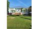 Charming beach house with a blue exterior, inviting porch, and lush green lawn at 166 Catfish St, Haines City, FL 33844