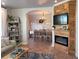 Cozy living room that flows into the dining room, featuring tile floors and a wood-paneled fireplace at 166 Catfish St, Haines City, FL 33844