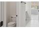 Bright bathroom featuring a toilet, tiled floors, and a vanity with a view to the outside at 2797 Top Hill Ct, Minneola, FL 34715