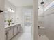 Bright bathroom with double vanity, tiled shower with bench, and modern fixtures at 2797 Top Hill Ct, Minneola, FL 34715