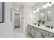Bright bathroom features double vanity, white countertops, and a walk-in shower and walk-in closet at 2797 Top Hill Ct, Minneola, FL 34715