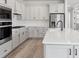 Modern kitchen with white cabinetry, stainless steel appliances, and a spacious center island at 2797 Top Hill Ct, Minneola, FL 34715