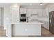 Bright kitchen features white cabinets, stainless appliances, and a spacious island with white countertop at 2797 Top Hill Ct, Minneola, FL 34715