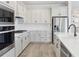 Well-equipped kitchen with stainless steel appliances, white countertops and cabinetry, and hardwood floors at 2797 Top Hill Ct, Minneola, FL 34715