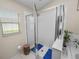 White tiled walk-in shower with glass doors and a window for natural light at 4662 Harts Brook Ln, Mulberry, FL 33860