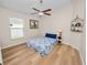 Bedroom featuring wood-look floors, ceiling fan, and coastal decor at 4662 Harts Brook Ln, Mulberry, FL 33860