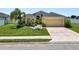 Well-maintained home featuring a manicured lawn and tropical landscaping at 4662 Harts Brook Ln, Mulberry, FL 33860