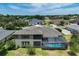 Aerial view of a home with a screened-in pool overlooking the manicured backyard and the neighborhood at 655 Whisper Woods Dr, Lakeland, FL 33813