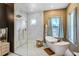 Bathroom featuring a walk-in shower, soaking tub, and double vanity with elegant fixtures at 655 Whisper Woods Dr, Lakeland, FL 33813