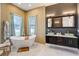 Bright bathroom featuring a soaking tub, elegant vanity, and marble tile flooring at 655 Whisper Woods Dr, Lakeland, FL 33813
