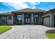 Stunning home exterior featuring a gray brick driveway, manicured lawn, and a beautifully landscaped yard at 655 Whisper Woods Dr, Lakeland, FL 33813