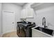 Well-organized laundry room equipped with modern appliances, storage cabinets, and sink at 655 Whisper Woods Dr, Lakeland, FL 33813